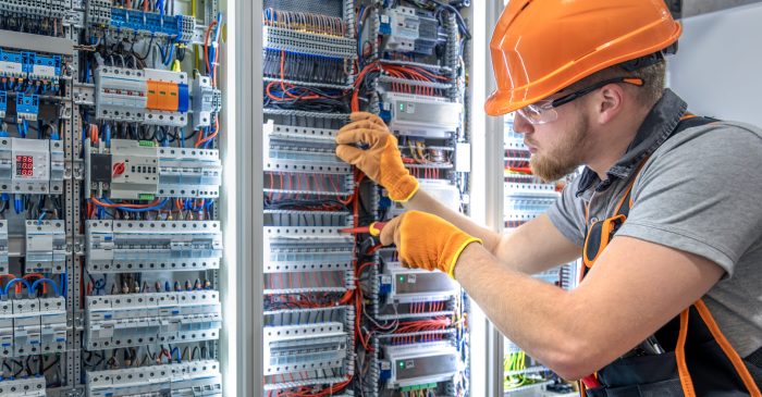 Male electrician working in electrical panel. Male electrician in uniform. High quality photo. Male construction worker in helmet and safety glasses. Copy space. SSUCv3H4sIAAAAAAAAA41P0W6DMAz8Fz8HqSEbTfmVag8BG2oVSJWYVRPKvy+hVHtdnu588d15A0ZowSIa/HCnahgQK61pqCzW50oP9tOc7cVSbUABOiFotTG2aYzWTW0vp/IUdC5yD+0GPE1rlOCE/QJtVgItSGGHhCw+sJsySwqiOFkjxbyWWZ+9x6zu/O133co8F8zhce0KSOqfsy8FbqSl/yn+qRSZyO1x1yzdn0JhPrK93ErFAh+Be17Go1M+xc8vvHgpu3uC+P7OeCy/zrhxnoaSBetj8g4JD3ntZhZ500DfTM+/3ymlX+deR/CEAQAA