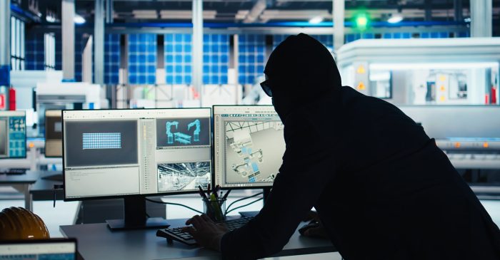 Masked worker in photovoltaics factory commits corporate espionage, stealing proprietary technology using USB stick. Man exploits insider access to copy trade secrets from solar panel plant, camera A